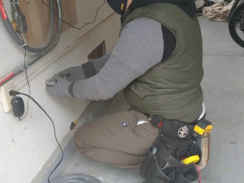 Electrician performing outlet wiring in a Harper Woods garage